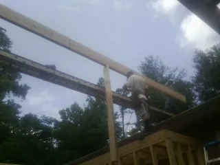 Carpenter setting a ridge beam over a new addition frame — Ice Dam Removal by Roofing Brothers in Bonaire