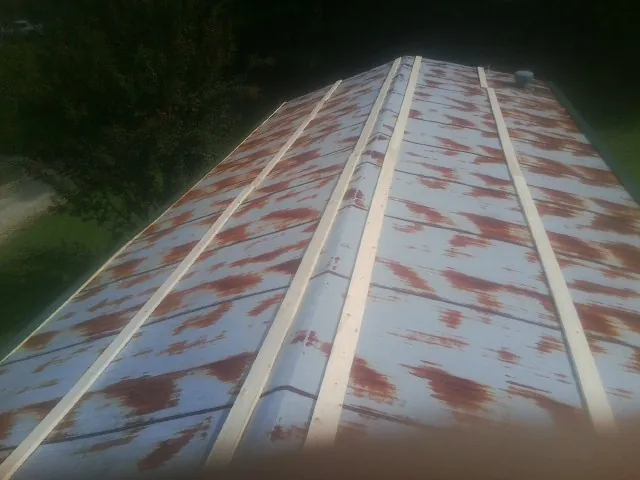 Rusted metal roof panels with new wood purlins before replacement — Storm Damage Roof Repair in Bonaire by Roofing Brothers